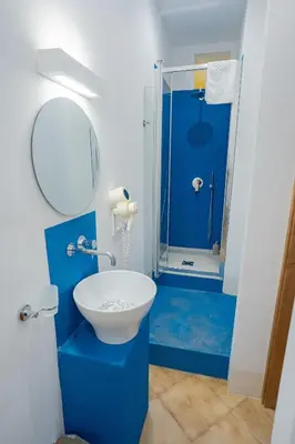 a blue bathroom with a sink and a shower at Himera Domus 2 in Termini Imerese