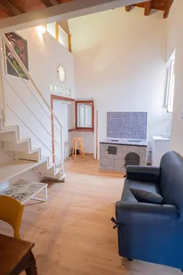 a living room with a blue couch and a staircase at Himera Domus 2 in Termini Imerese
