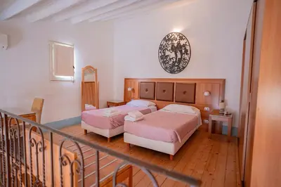 a hotel room with two beds and a balcony at Himera Domus 2 in Termini Imerese