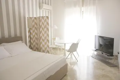 a bedroom with a bed and a tv and a table at Dream on the blue house Palermo in Palermo