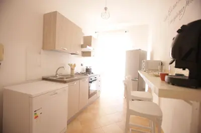 a white kitchen with a sink and a counter at Dream on the blue house Palermo in Palermo