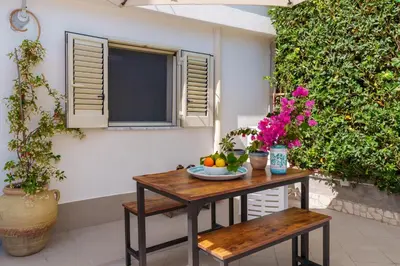 a table with fruit and flowers on a patio at Casa Vacanze Villa Rosa Mondello in Palermo