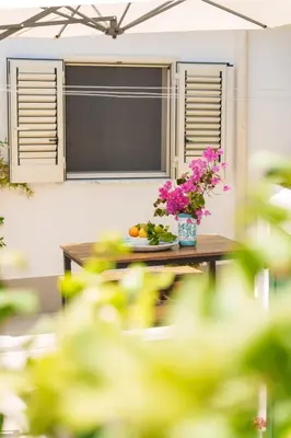 a table with a vase of flowers on it at Casa Vacanze Villa Rosa Mondello in Palermo