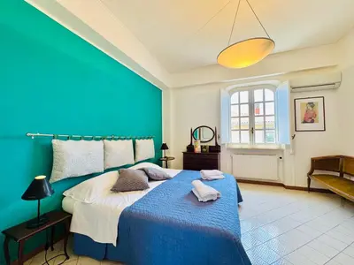 a bedroom with a blue bed with towels on it at Villa Crilulù al Mare in Palermo