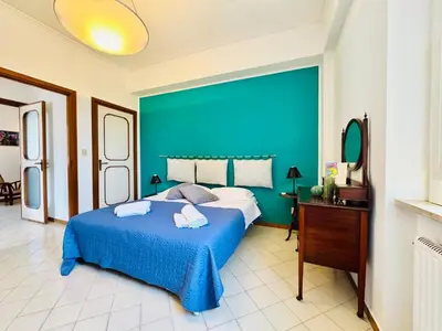 a blue bedroom with a bed and a blue wall at Villa Crilulù al Mare in Palermo