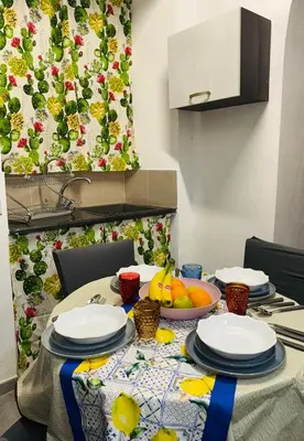a table with plates and bowls of fruit on it at Shamà rooms in Palermo