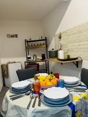 a table with plates and a bowl of fruit on it at Shamà rooms in Palermo