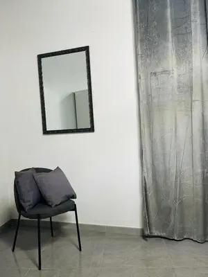 a chair in a room with a mirror on a wall at Shamà rooms in Palermo