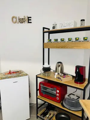 a kitchen with a shelf with a microwave and a refrigerator at Shamà rooms in Palermo