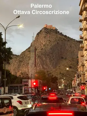 a busy city street with cars parked in front of a mountain at Fantastic sea view Via Duchessa in Castellammare del Golfo
