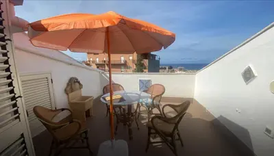 a patio with a table and chairs and an umbrella at Fantastic sea view Via Duchessa in Castellammare del Golfo