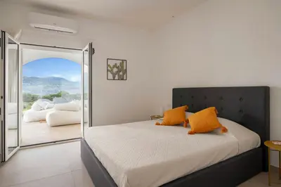 a bedroom with a bed with orange pillows at Historic Villa Overlooking Scopello Sea Stacks in Castellammare del Golfo