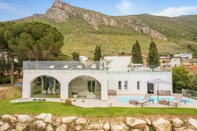 a villa with a swimming pool and mountains in the background at Historic Villa Overlooking Scopello Sea Stacks in Castellammare del Golfo