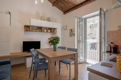 a kitchen and dining room with a wooden table and chairs at GuestHost - Don Pippo Flat near Teatro Massimo in Palermo