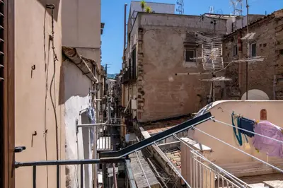 an alleyway in an old city with buildings at GuestHost - Don Pippo Flat near Teatro Massimo in Palermo