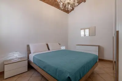 a bedroom with a bed and a chandelier at GuestHost - Don Pippo Flat near Teatro Massimo in Palermo