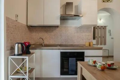 a kitchen with white cabinets and a sink at GuestHost - Don Pippo Flat near Teatro Massimo in Palermo