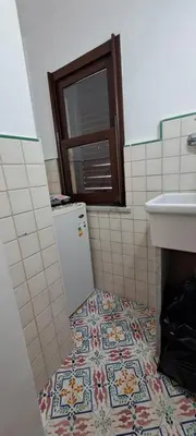 a bathroom with a tile floor with a refrigerator at Casa Mazzini in Carini