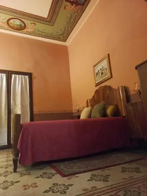 a bedroom with a bed with a purple blanket at Casa Mazzini in Carini