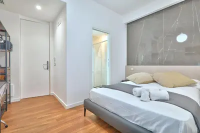 a bedroom with a large bed with white walls at belMORO - La Dimora Del Capo in Palermo