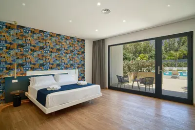 a bedroom with a bed and a sliding glass door at Ella Suites Apartments in Terrasini