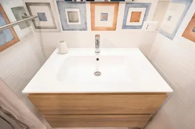 a white sink in a bathroom with pictures on the wall at Flat in Center in Palermo