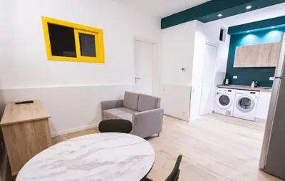 a living room with a table and a chair at Flat in Center in Palermo