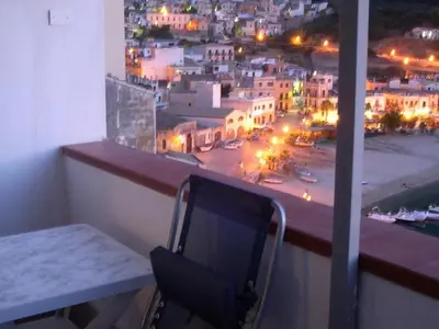a balcony with a table and a view of a city at Angolo di CIELO in Castellammare del Golfo