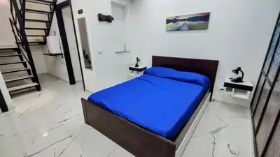 a bedroom with a bed with a blue blanket at Roccaforte House - Palermo in Palermo