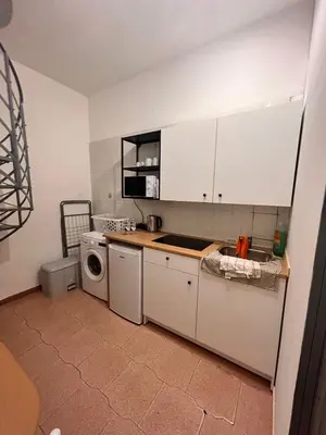 a kitchen with white cabinets and a washing machine at Porte Rosse in Casteldaccia