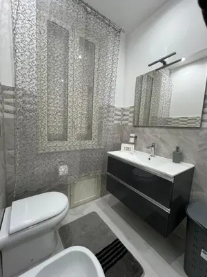 a bathroom with a white toilet and a sink at Angela apartments in Partinico