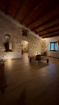 a room with a table and a stone wall at Dimora Donna Carmela in Capaci