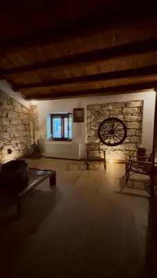 a living room with a stone wall and a table at Dimora Donna Carmela in Capaci