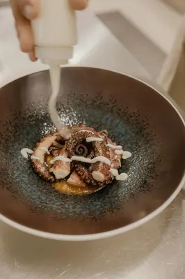 a person drizzling icing on a doughnut in a pan at Palmar Boutique Hotel in Campofelice di Roccella