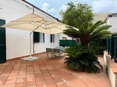 a patio with an umbrella and a table and chairs at Casa Baglio Monti in Palermo