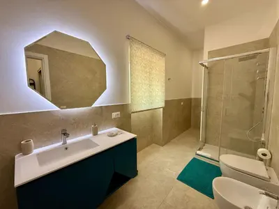 a bathroom with a sink and a shower with a mirror at Casa Baglio Monti in Palermo
