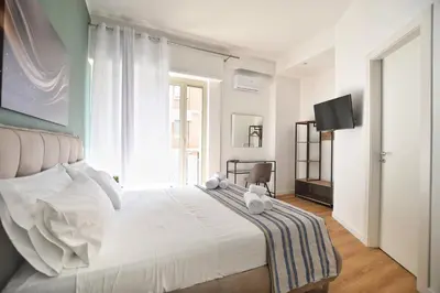 a bedroom with a large white bed and a television at iFlat Papi living in Palermo