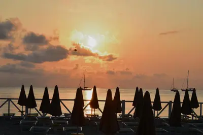 a group of umbrellas on the beach at sunset at Oasi Palma - Mondello in Palermo