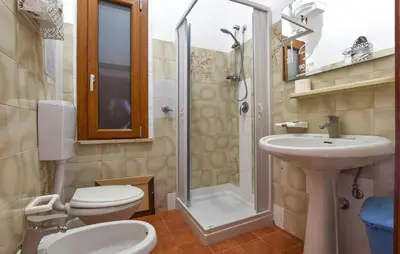 a bathroom with a toilet and a sink and a shower at Beach Front Apartment In Trappeto in Trappeto