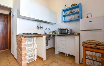 a kitchen with white cabinets and a white refrigerator at Beach Front Apartment In Trappeto in Trappeto