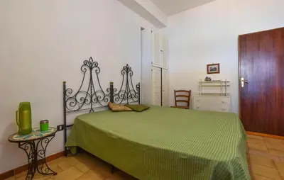 a bedroom with a green bed and a wooden floor at Beach Front Apartment In Trappeto in Trappeto