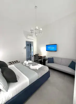 a bedroom with a large bed and a couch at Foresteria del Genio - Luxury Suites & Urban Spa in Palermo