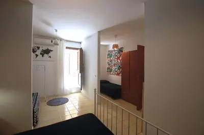 a room with a staircase with a window and a chair at Appartamento Bouganville in Castellammare del Golfo