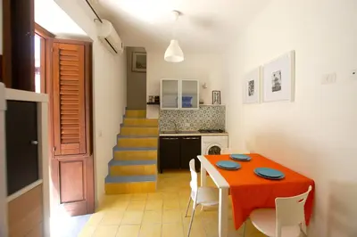 a kitchen and dining room with a table and chairs at Appartamento Bouganville in Castellammare del Golfo