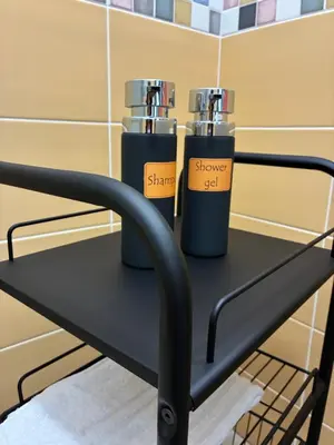 two bottles on a black shelf in a bathroom at D & C Apartment in Palermo