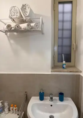 a bathroom with a sink and a mirror and towels at DomusSolis - Casa vacanza a 2 passi dal mare in Palermo