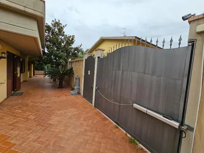a fence next to a brick sidewalk next to a house at Villa Nino in Palermo