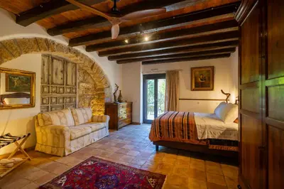 a bedroom with a bed and a couch in a room at Villa Cannamele in Carini