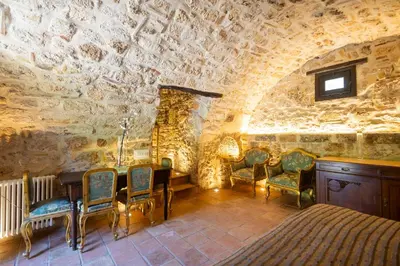 a room with a table and chairs in a stone wall at Villa Cannamele in Carini