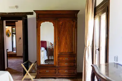 a wooden cabinet with a mirror in a room at Villa Cannamele in Carini